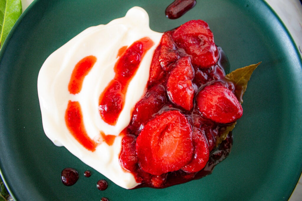 stewed strawberries with bay leaves over yogurt for breakfast bowl.