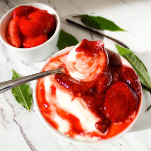 stewed strawberries with bay leaves in breakfast bowl over yogurt.