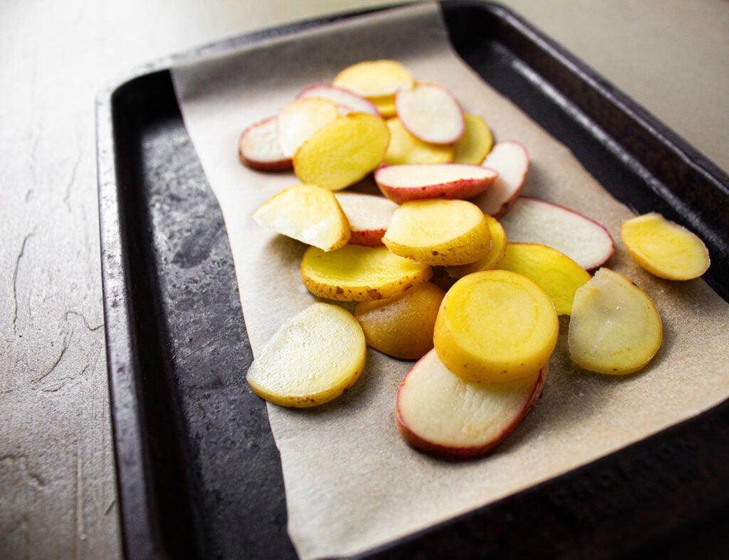 sliced potato's on baking sheet.