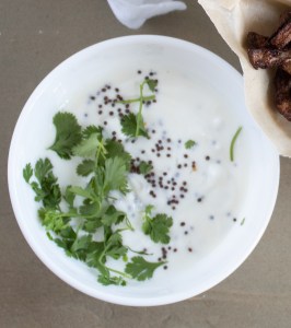 bowl of white yogurt with green cilantro leaves