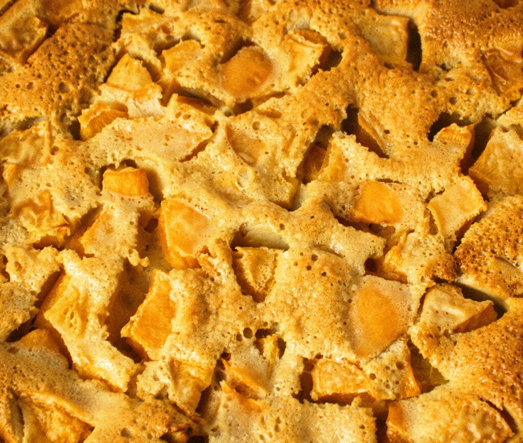 close up texture of apricot clafoutis infused with chamomile flowers. 