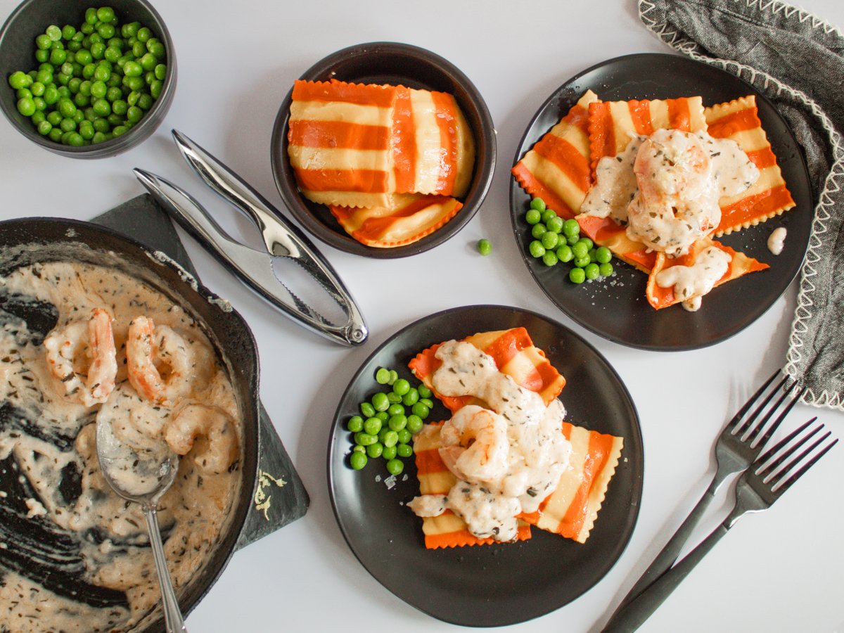 lobster ravioli on plates with green peas.