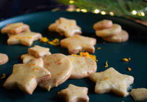 iced ginger and orange sugar cookies on green platter.