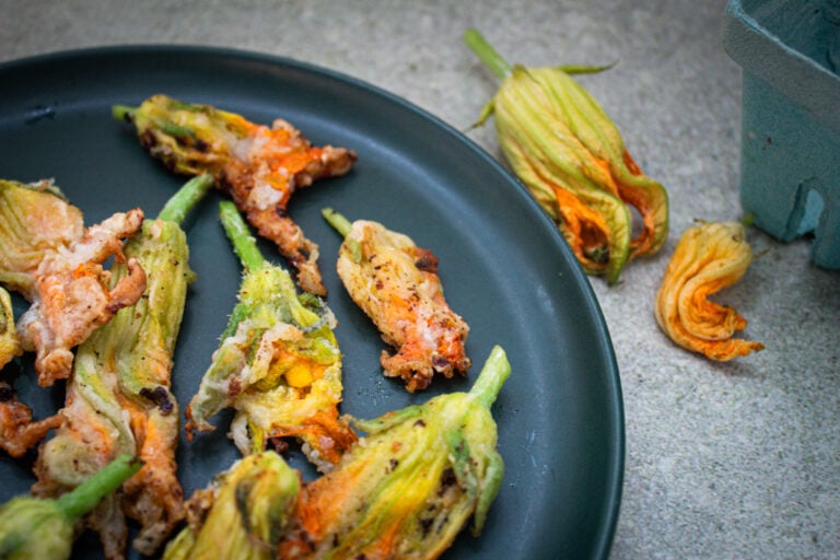 A plated of stuffed and fried squash blossoms ready t be eaten.