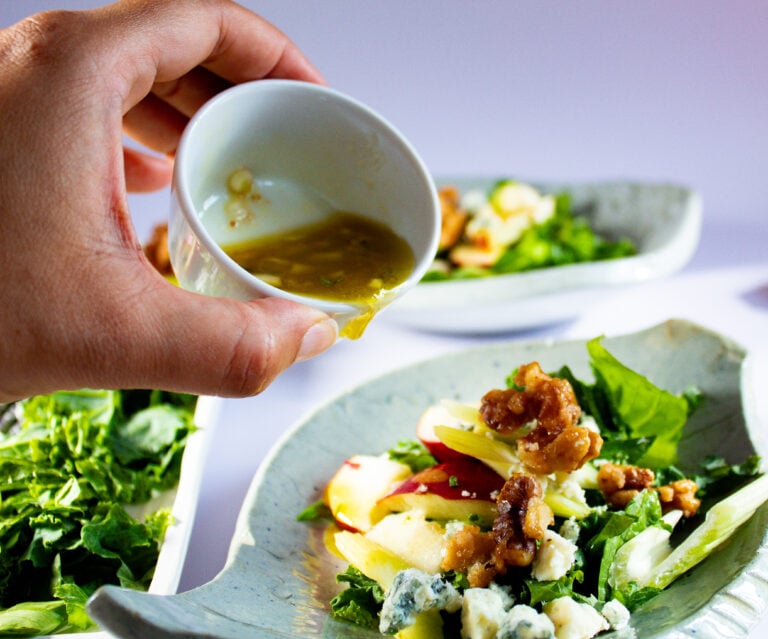 fig vinaigrette poured over kale salad.