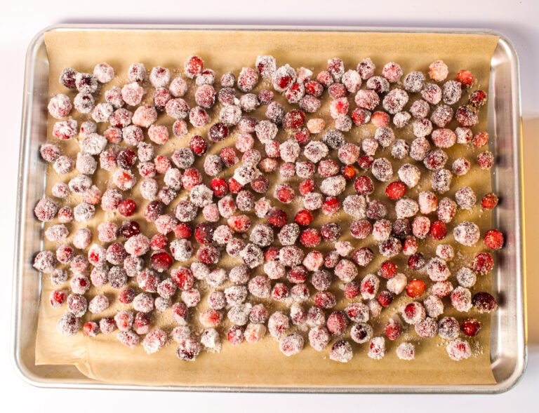 baking tray of cranberries covered in sugar and left to dry.