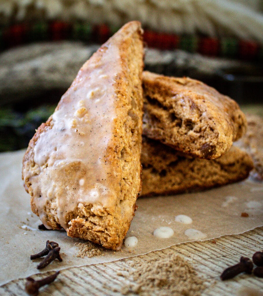 Close-up of a tender gingerbread scone topped with a sweet vanilla icing drizzle