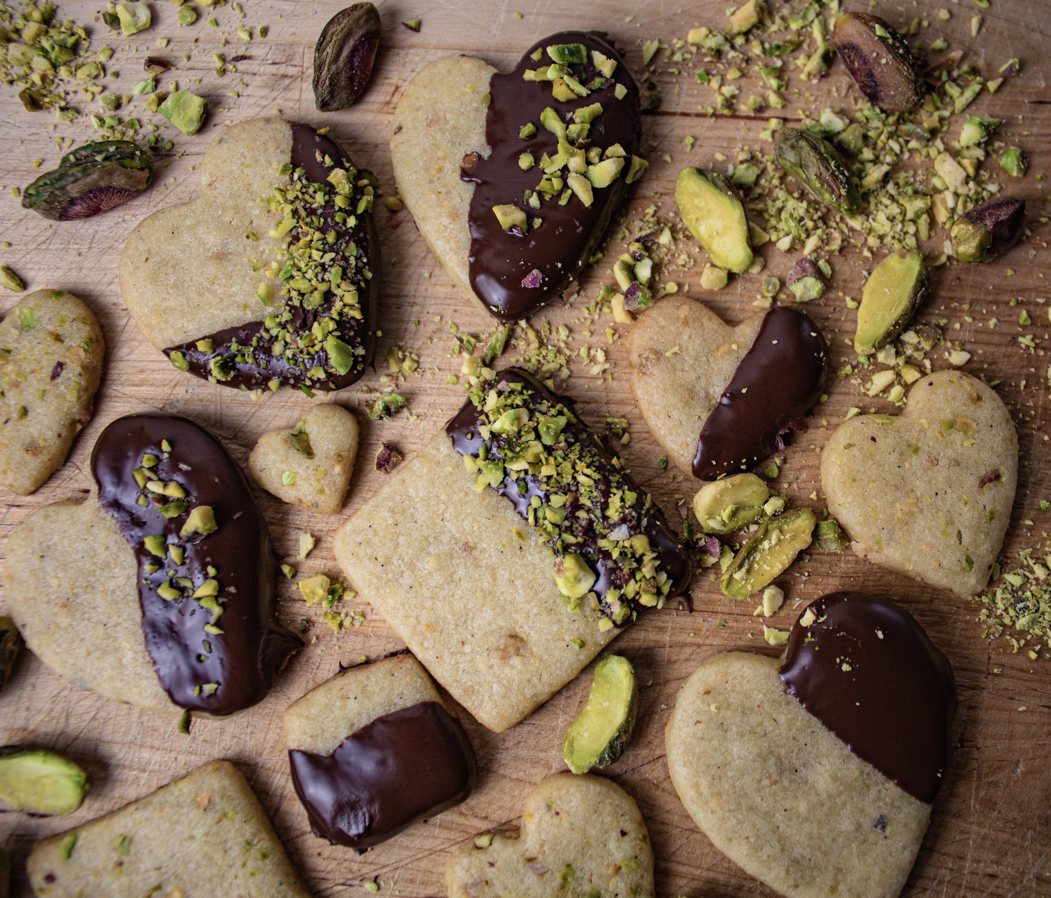 Dark chocolate dipped pistachio cookies sprinkled with crushed pistachios.