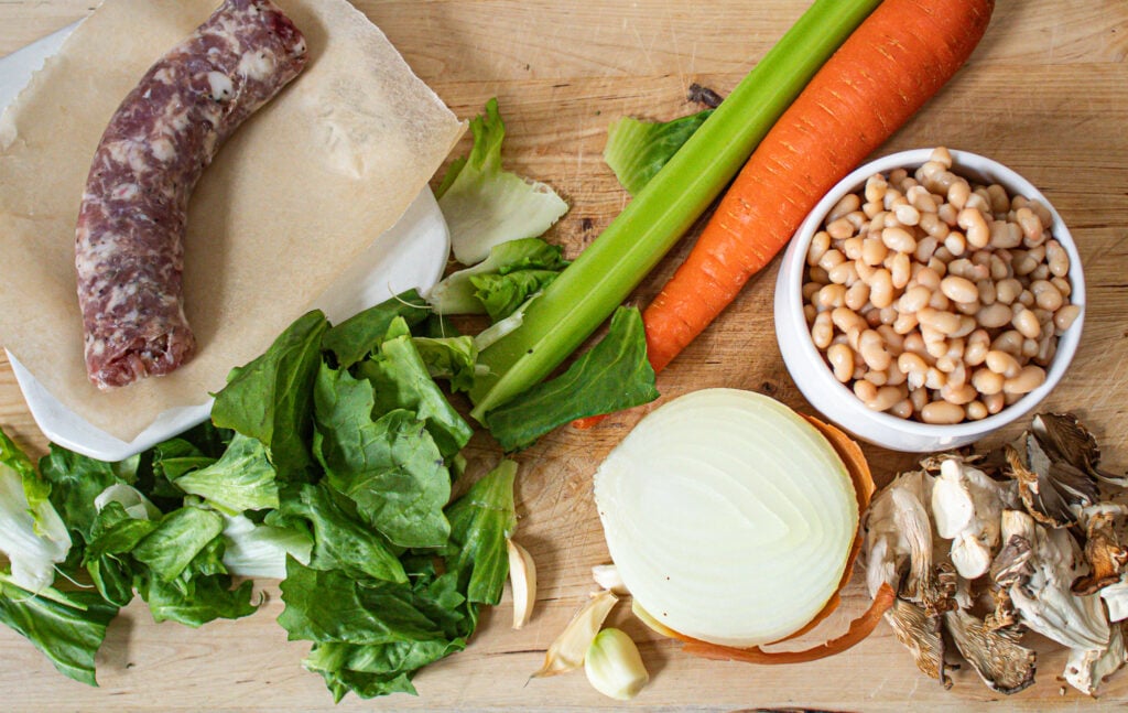 Ingredients for sausage, escarole and white bean soup with mushrooms.