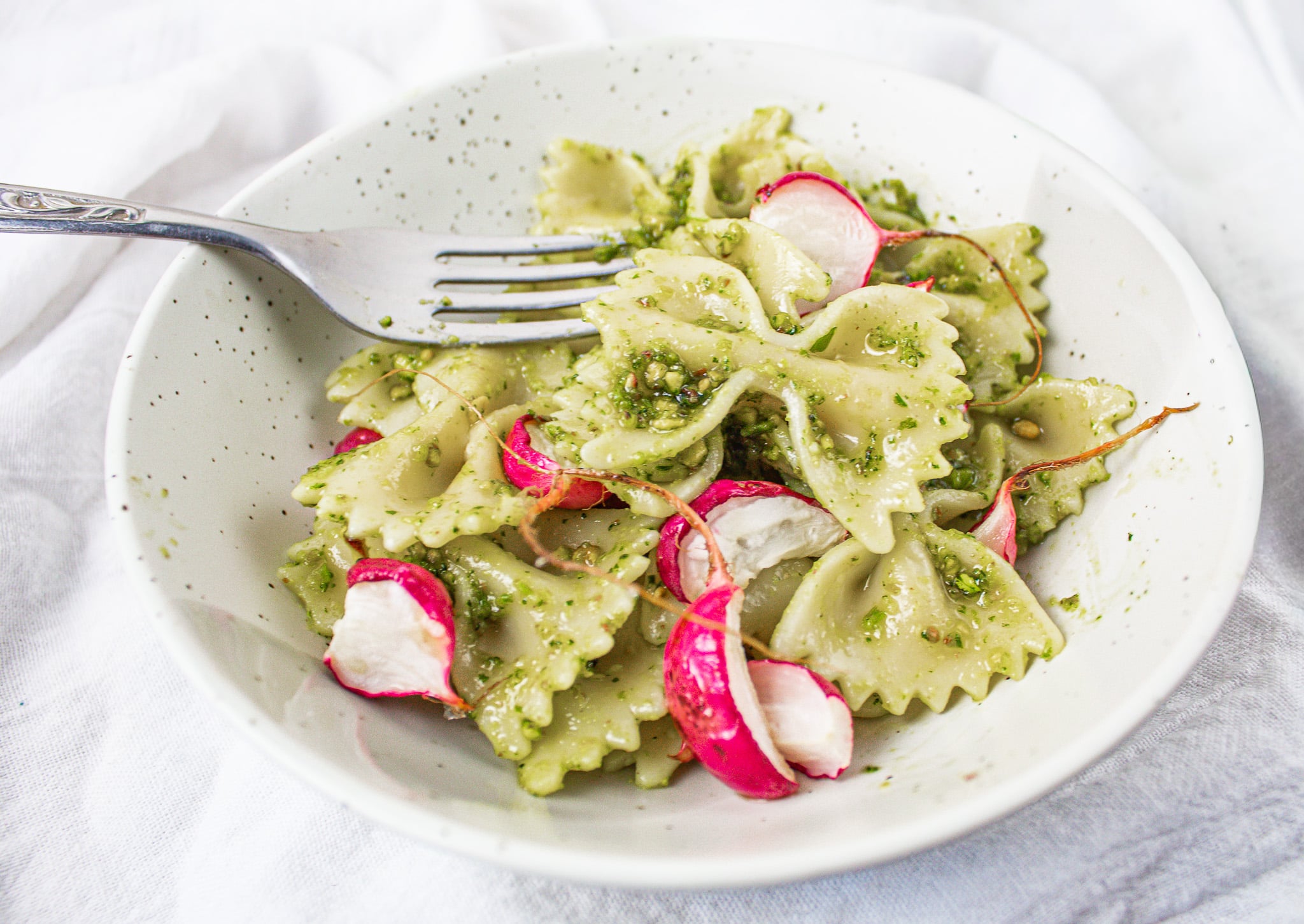 farfalle pasta with pea shoot pesto and roasted radish.