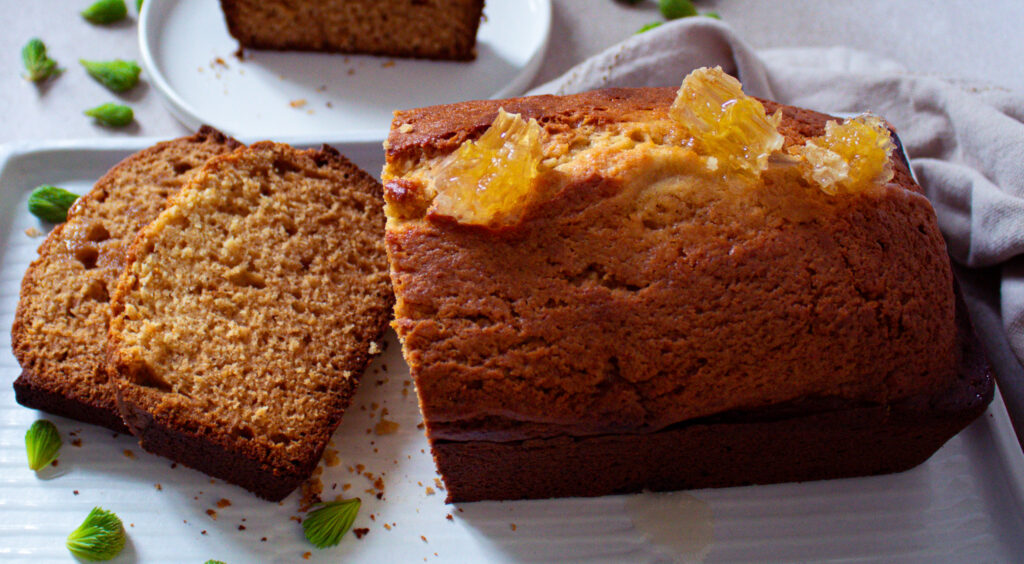 Spruce tip honey loaf cake with honey comb as garnish.